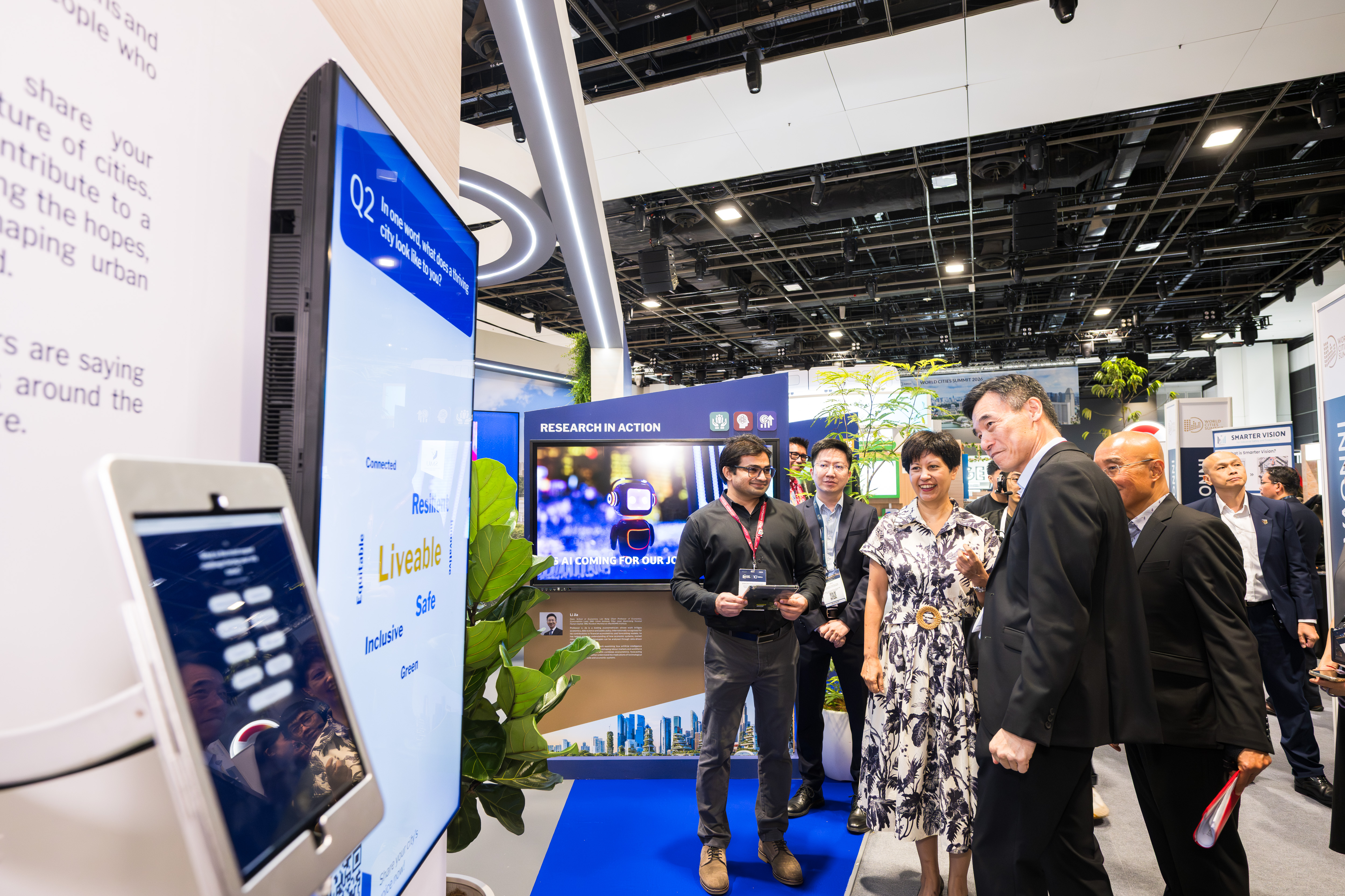 Christopher Chew, VP (Corporate Communications & Marketing), introducing the multi-disciplinary content to Minister Indranee Rajah at SMU's exhibition booth on the opening day of WCS 2026.