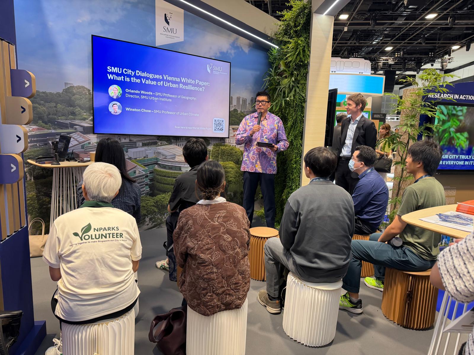 Prof Winston Chow and Prof Orlando Woods sharing on urban resilience at the SMU exhibition booth on 16 Jun 2026 at the World Cities Summit.