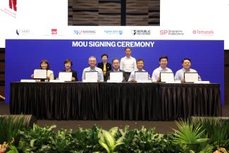 Mr Tan Wee Beng and Prof Lily Kong witnessed the MOU Signing Ceremony. Seated from L-R are representatives from the Institute of Technical Education, Nanyang Polytechnic, Ngee Ann Polytechnic, SMU, Republic Polytechnic, Singapore Polytechnic and Temasek Polytechnic.
