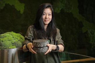 Magorium co-founder Oh Chu Xian with prototypes of road construction material the start-up has developed. The firm's road construction material prototypes have incorporated plastic bottles, plastic bags and milk cartons - waste that has been reprocessed into pellets to be added to the asphalt when paving roads. ST PHOTO: ONG WEE JIN