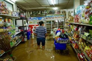 A resident wading through flood waters at a convenience store in Chiang Mai on Oct 6 after Typhoon Yagi swept through Northern Thailand in September. PHOTO: AFP