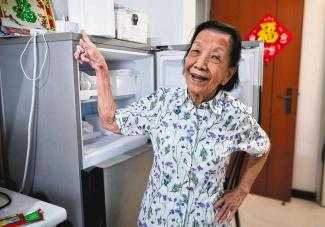 Ms Julie Chia, 97, pointing to a motion sensor on her fridge. She is among more than 200 seniors who have been recruited since 2020 for the Sensors In-home for Elder Wellbeing study. The sensors monitor movement and daily routines discreetly, including sleep patterns, physical activity and memory lapses. ST PHOTO: TARYN NG
