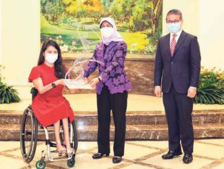 President Halimah Yacob (centre), together with Minister for Culture, Community and Youth Edwin Tong (right) presenting the trophy to Yip Pin Xiu at the Istana on Feb 11, 2022. PHOTO: LIANHE ZAOBAO