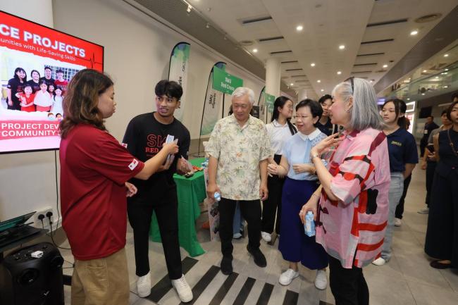 Students sharing more about their club’s activities at their booth with Prof Lily Kong, Dr Lillyn Teh and Dr Foo Suan Tong.