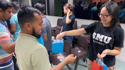 Mas, leader of Project Candela 3, engaging migrant workers with games and prizes – building bonds across communities.